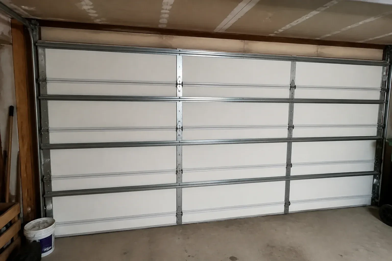 Interior of a closed sectional door with horizontal metal reinforcement struts. — Wind-Rated Garage Door Replacement, Kawartha Lakes